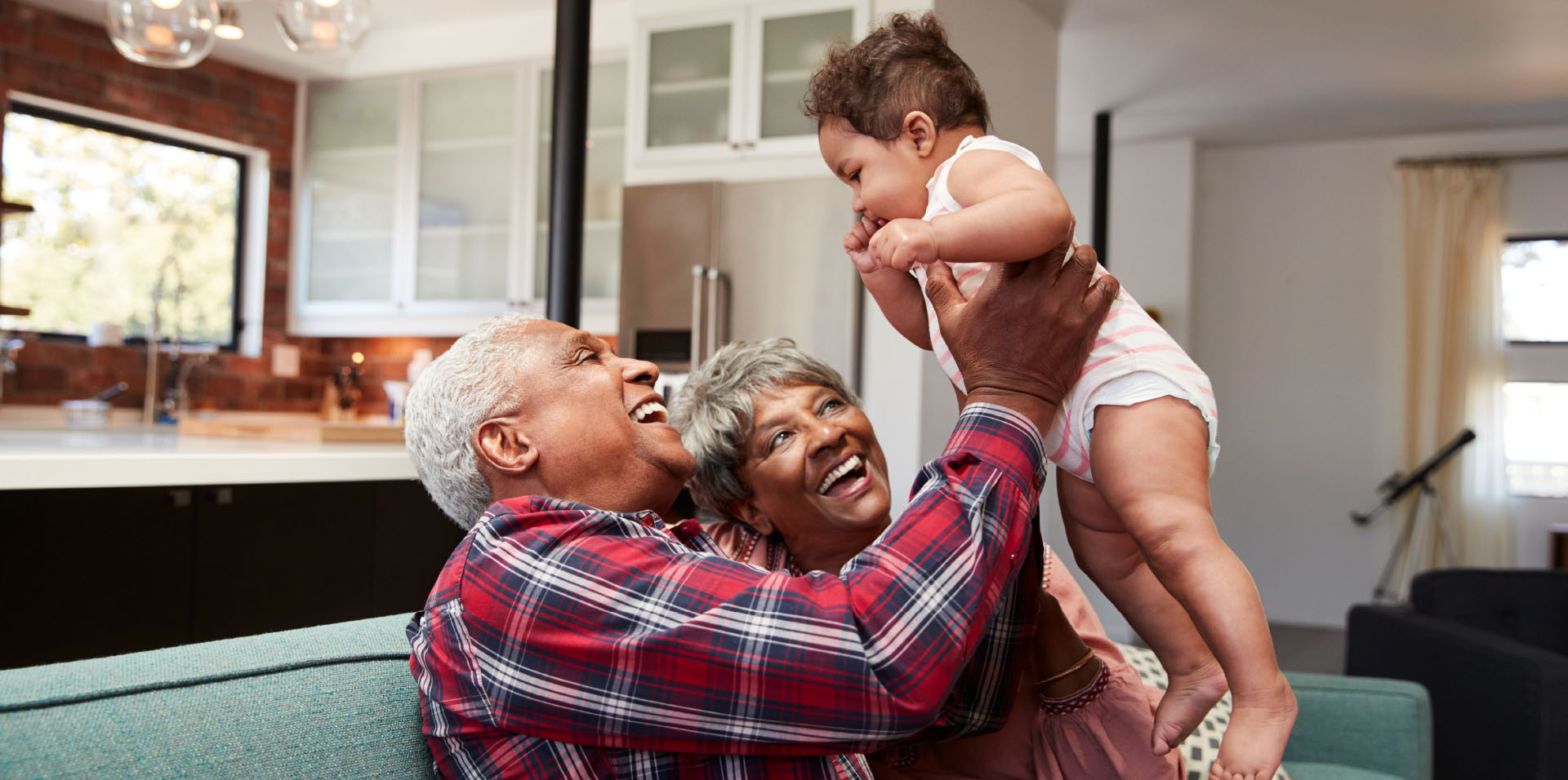 Grandparents holding up baby
